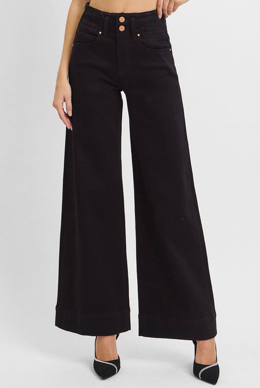 Black wide-leg jeans worn by a person on a white background