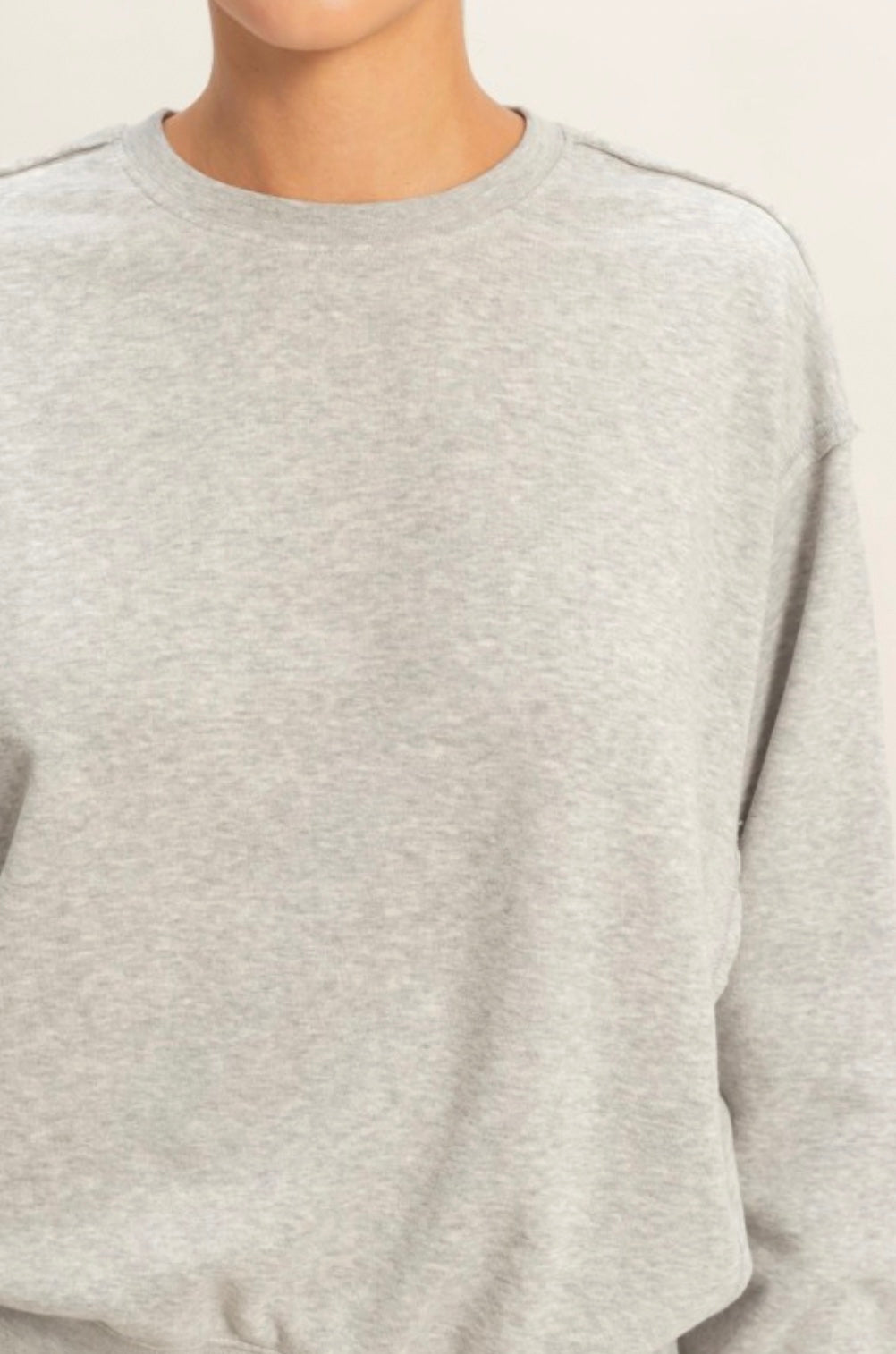 Gray sweater worn by a person on a white background